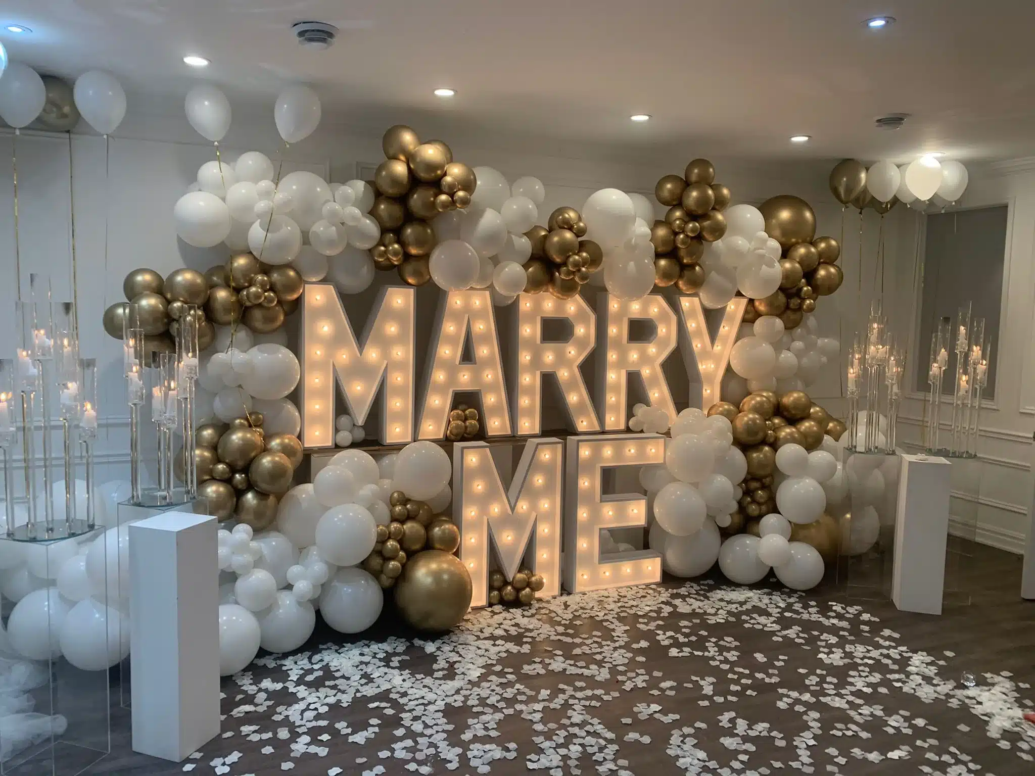 MARRY ME lichtletters met gouden ballondecor tijdens een aanzoek